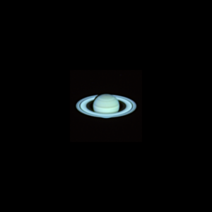 The image shows Saturn with the orientation looking down on the rings. The planet shows subtly colored bands in the atmosphere and a a bit of the planet's shadow on the far side of the rings. There is also a hint of the planet visible both through the main gap in the rings as well as a tiny amount of the planet visible below the rings.